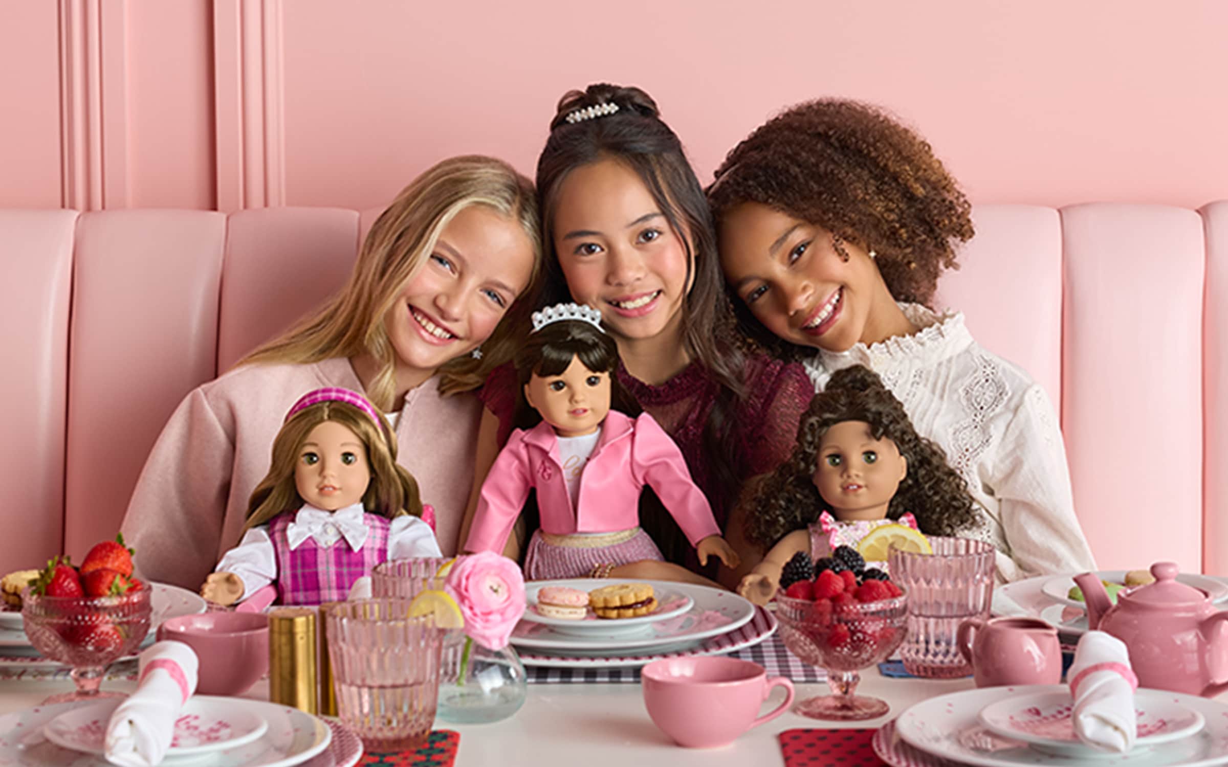 Image of three girls holding American Girl dolls at an American Girl cafe